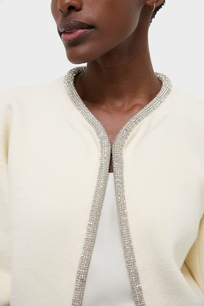 Model wearing the Ivory Sequin Trim Naomi Cardigan, featuring a classic and effortless design with sparkling trim, embodying Tuckernuck's fun and high-end style.