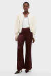 Model wearing the classic Ivory Sequin Trim Naomi Cardigan with metallic accents, paired with burgundy trousers, embodying an effortless, high-end style with a fun, modern twist.