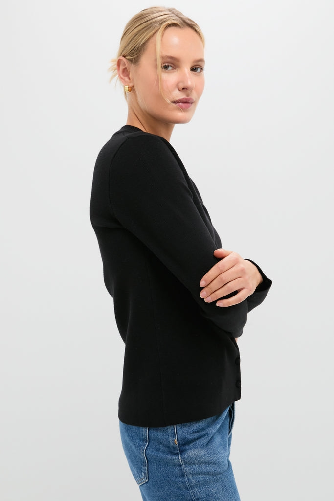 Woman in profile wearing the classic Black Viscose Margaux Cardigan, embodying effortless style with medium-wash jeans, perfect for a high-end, fun shopping experience.