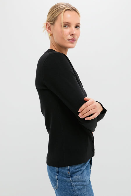 Woman in profile wearing the classic Black Viscose Margaux Cardigan, embodying effortless style with medium-wash jeans, perfect for a high-end, fun shopping experience.