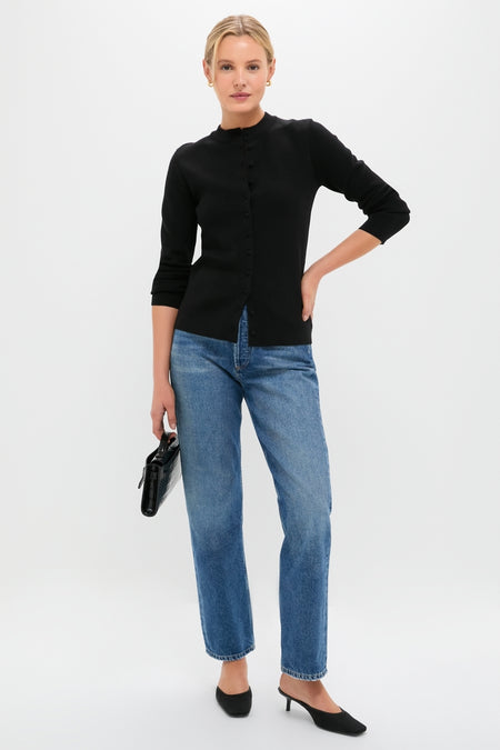 Woman in Black Viscose Margaux Cardigan, exuding classic elegance and effortless style, paired with straight-leg jeans and slingback shoes, holding a chic black handbag.