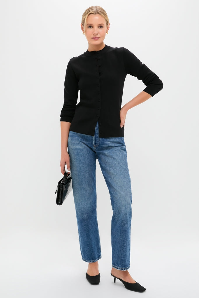 Woman in Black Viscose Margaux Cardigan, exuding classic elegance and effortless style, paired with straight-leg jeans and slingback shoes, holding a chic black handbag.