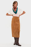 Woman wearing HB x Tuckernuck Texas Strong Scarf, styled effortlessly with a graphic T-shirt, camel suede skirt, and embroidered cowboy boots; exuding classic, high-end fashion.