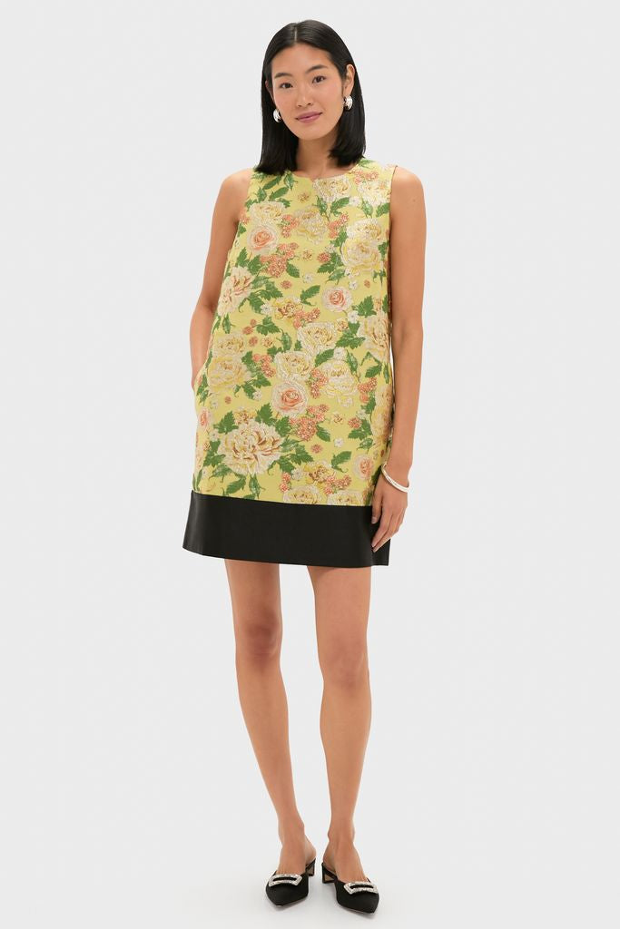 Model wearing the Chrysanthemum Jacquard Arcati Dress with a classic shift silhouette, floral jacquard pattern, and contrast hem, styled with black mules and silver hoops. Effortlessly high-end.