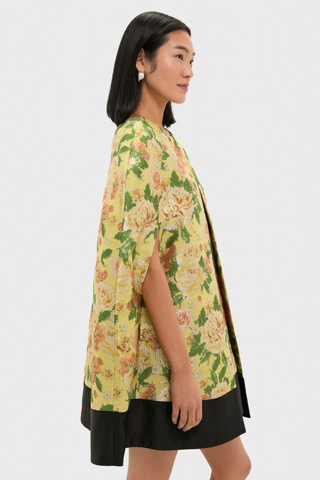 Effortlessly chic, the Chrysanthemum Jacquard Noel Cape features a classic floral pattern, poncho silhouette, and elegant trim, perfect for a high-end, fun look.