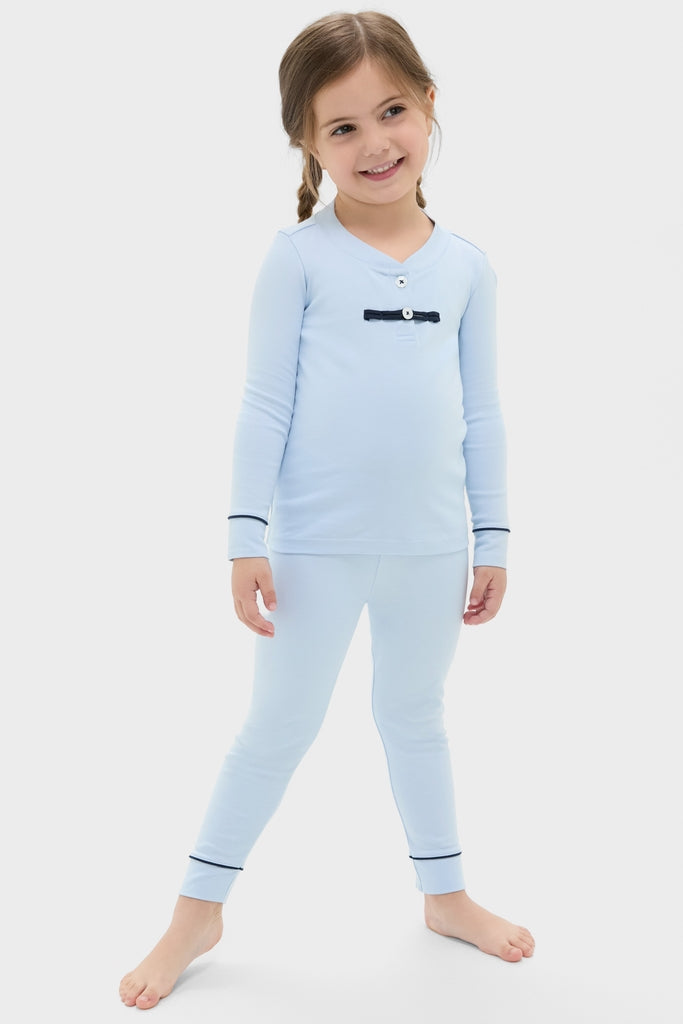 Young girl in classic, light blue Pima Cotton Arien Kid's Pajama Set with contrast trim, embodying effortless style and fun, high-end comfort.