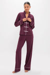 Model wearing the classic Winetasting Wilford Women's Pajama Set with Mandarin collar and frog buttons, exuding effortless elegance and high-end comfort in deep plum with white piping.