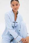 Young woman wearing the classic Light Blue Wilford Women's Pajama Set with a mandarin collar and black piped trim, embodying effortless style and high-end comfort.