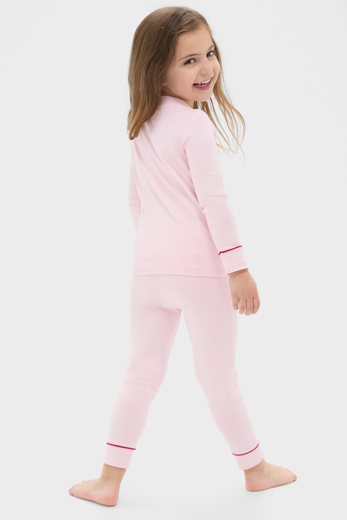 Young girl in a classic Pink Arien Kid's Pajama Set with a mandarin collar and red trim, embodying effortless comfort and fun style.