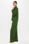 Woman models the classic Green Wilford Women's Pajama Set, featuring an effortless dark-green top and wide-leg pants with yellow piping, embodying fun and high-end loungewear style.