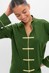 Woman wearing the classic Green Wilford Women's Pajama Set, featuring an effortless mandarin collar and frog-toggle closures, smiling softly, embodying Tuckernuck's fun, high-end style.