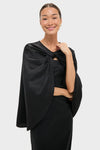 Classic elegance meets effortless style with the Black Satin Mountbatten Cape, draped over a form-fitting dress, perfect for a high-end, fun, and confident look.