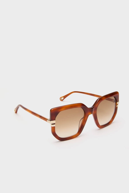 Shiny Blonde Havana West Sunglasses featuring oversized square frames in tortoiseshell acetate, with brown gradient lenses and gold-tone accents, embody a classic, effortless, and high-end style.