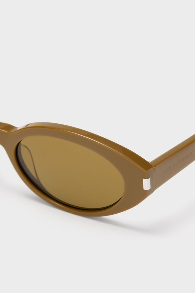 Shiny Solid Licorice Brown Corner Angle M Sunglasses featuring a classic, glossy olive-brown acetate frame and oval lenses, with SAINT LAURENT engraved on the temple arm. Effortless, fun, high-end.