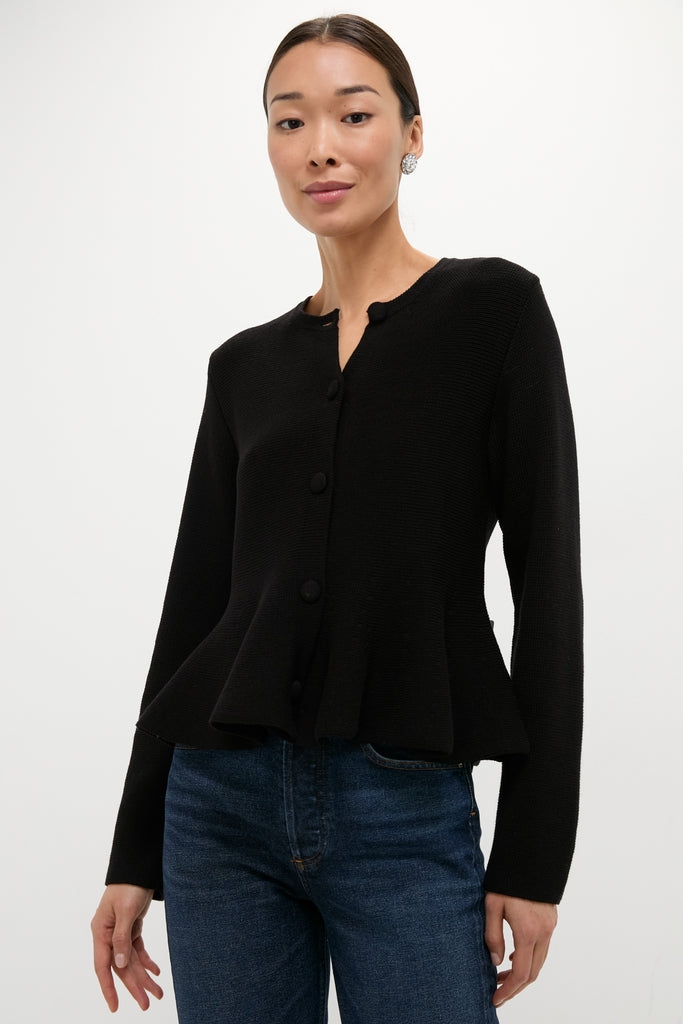 Model wearing the classic Black Knit Richmond Sweater with a slight peplum flair, paired effortlessly with jeans. This high-end, fun look embodies confidence and style.