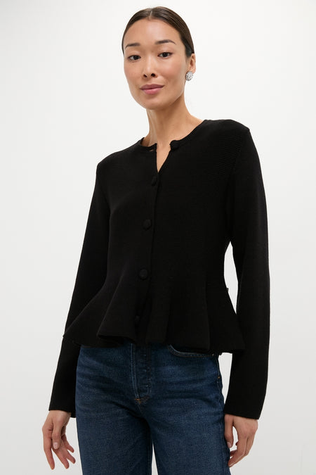 Model wearing the classic Black Knit Richmond Sweater with a slight peplum flair, paired effortlessly with jeans. This high-end, fun look embodies confidence and style.