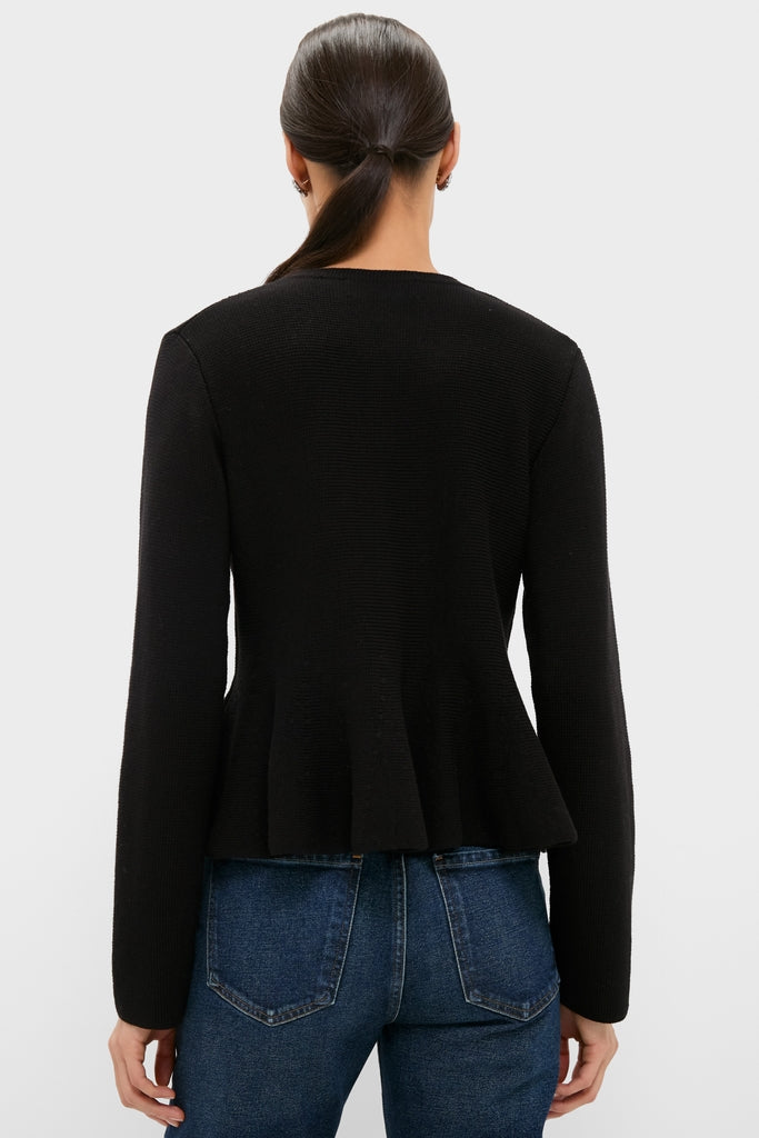 Woman wearing the Black Knit Richmond Sweater with a classic, subtle peplum and fitted design, paired with medium-wash jeans, showcasing an effortless, high-end look.