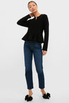 Woman wearing the classic Black Knit Richmond Sweater with a peplum flare, paired with straight-leg jeans and high-end mule heels, exuding an effortless, fun style.