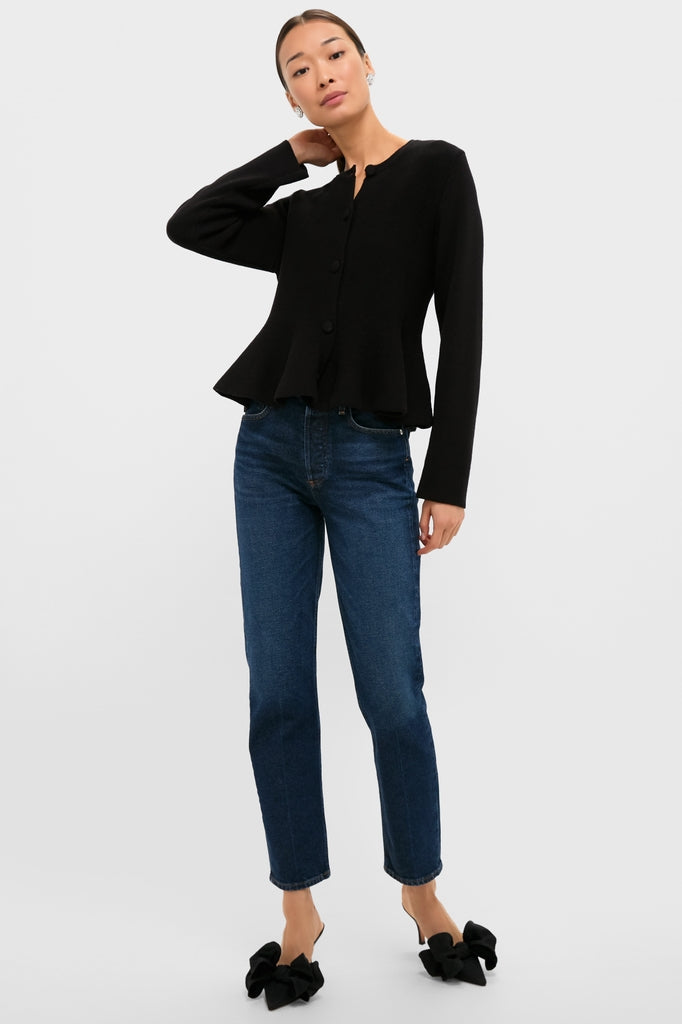 Woman wearing the classic Black Knit Richmond Sweater with a peplum flare, paired with straight-leg jeans and high-end mule heels, exuding an effortless, fun style.
