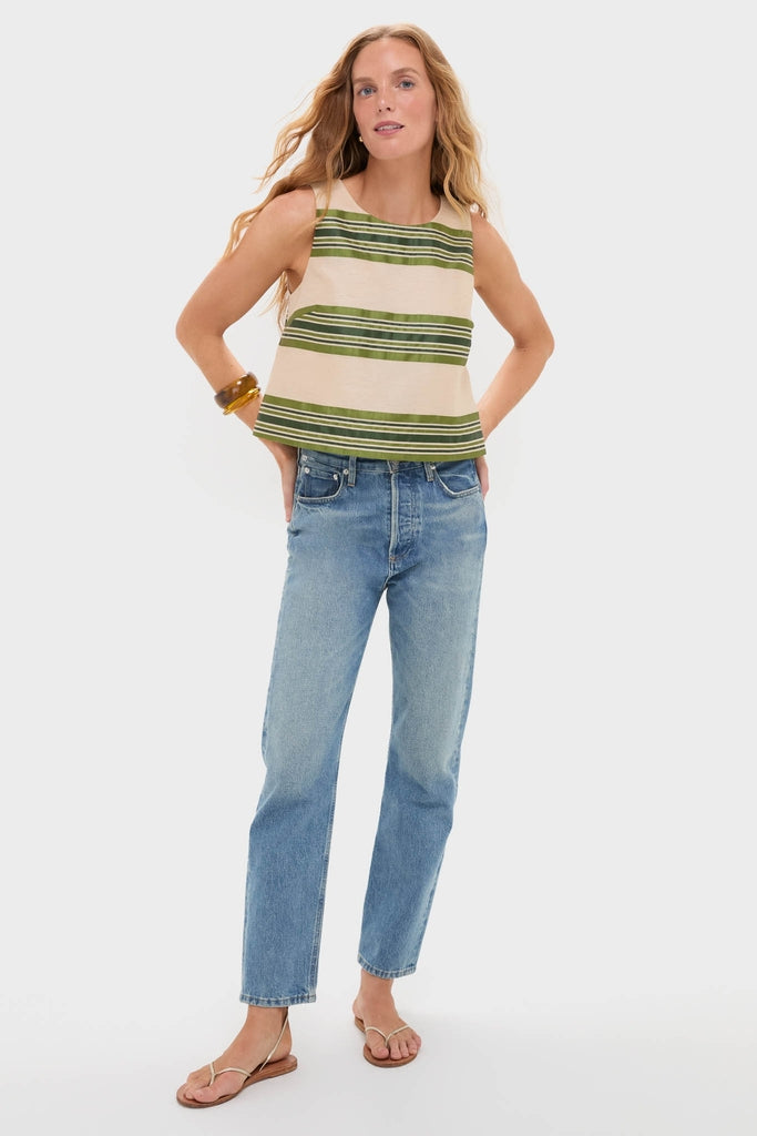 Woman in a classic, effortless Satin Stripe Kerri Top with olive and cream stripes, paired with jeans and sandals, embodying a fun, high-end style.