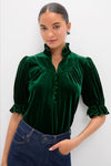 Hunter Green Velvet Selena Top features a classic high ruffled collar, puff sleeves, and covered buttons, paired with high-waisted jeans for an effortless, fun, high-end look.