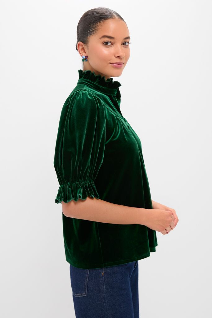 Young woman models the Hunter Green Velvet Selena Top, showcasing its classic high-end design with a ruffled neckline and puff sleeves for an effortless, fun look.