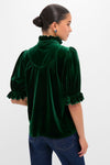 Hunter Green Velvet Selena Top with a ruffled collar and puff sleeves, styled with jeans, embodies a classic, effortless, and fun high-end look.
