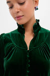 Person wearing the Hunter Green Velvet Selena Top with a ruffled collar and fabric-covered buttons, showcasing a classic, effortless, and high-end style.