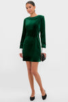 Model in the classic Hunter Green Velvet Etta Mini Dress, featuring removable white cuffs, holding a black clutch. Effortlessly high-end and fun for holiday parties.