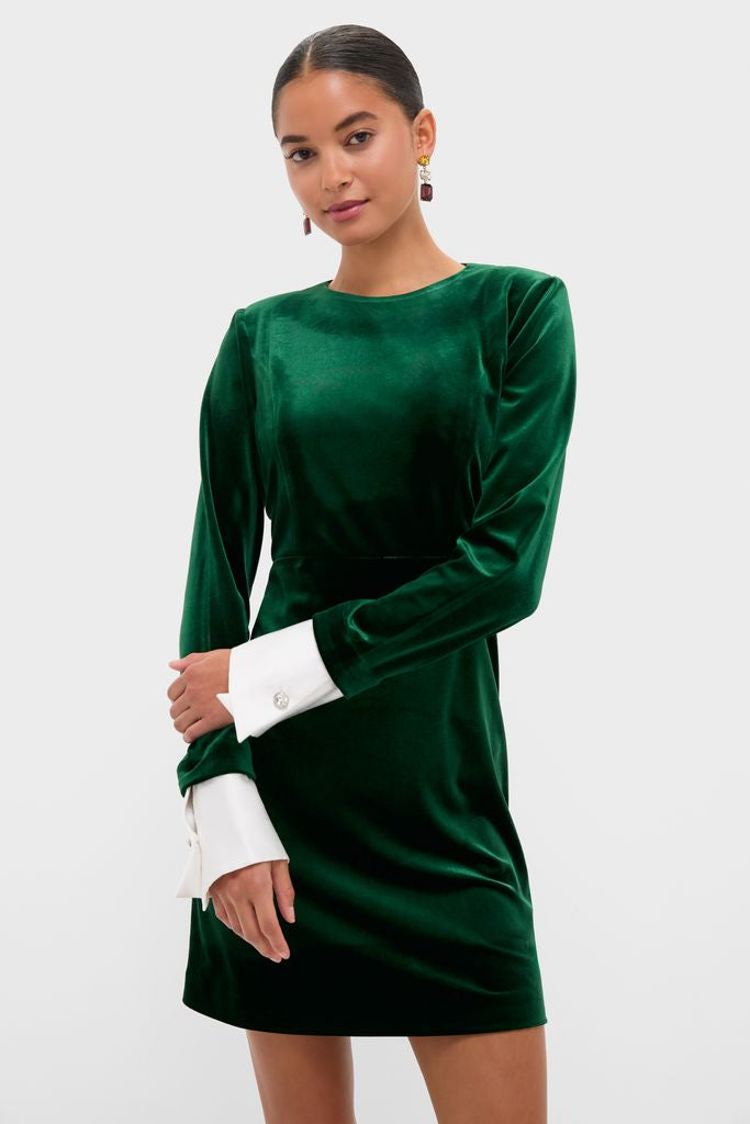 Hunter Green Velvet Etta Mini Dress modeled against a light background, showcasing its classic, high-end design with effortless style, featuring removable white cuffs and drop earrings.