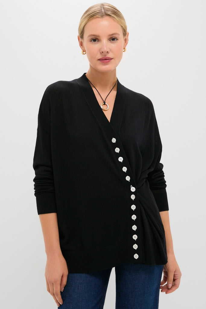 Model wearing Black Cross Button Calloway Cardigan, featuring an asymmetrical button placket and relaxed fit, paired with dark jeans for an effortless, high-end look.