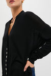 Black Cross Button Calloway Cardigan, a classic, effortless piece with asymmetrical buttons and side cinch, styled with jeans for a fun, high-end look.