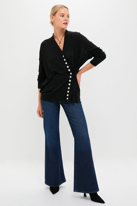 Model wearing the Black Cross Button Calloway Cardigan, styled with dark flared jeans and ankle boots, embodies a classic, effortless, and high-end look.