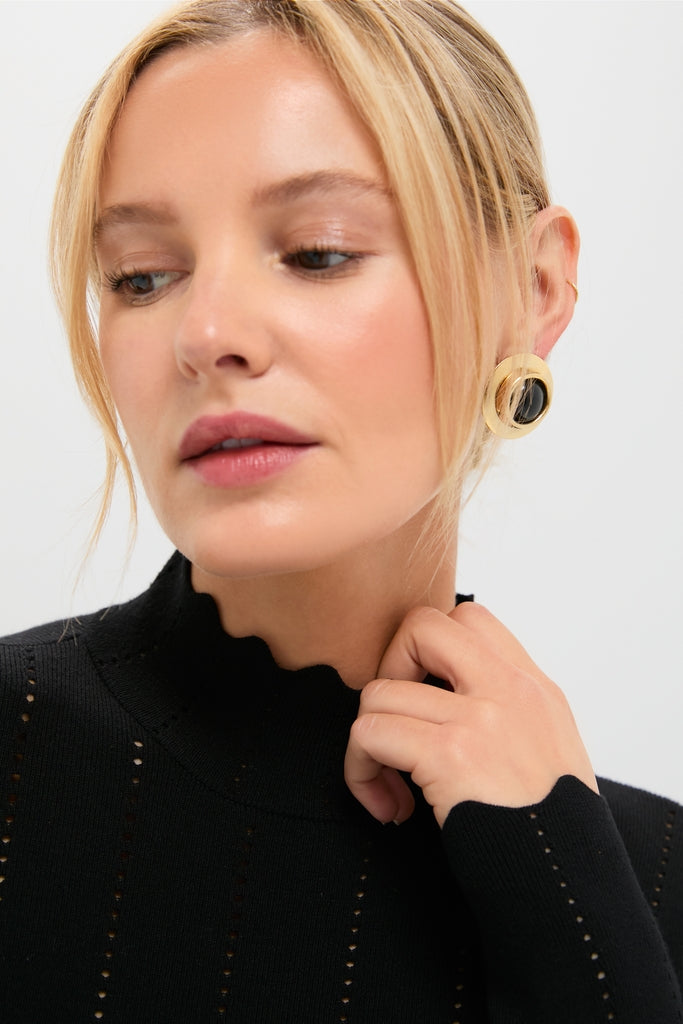 Woman in a Black Pointelle Knit Allen Turtleneck with scalloped mock-neck and statement hoop earring, embodying classic, effortless style.