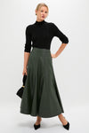 Woman models Black Pointelle Knit Allen Turtleneck with scalloped neckline, styled with an A-line midi skirt and black accessories, showcasing a classic, effortless, high-end look.