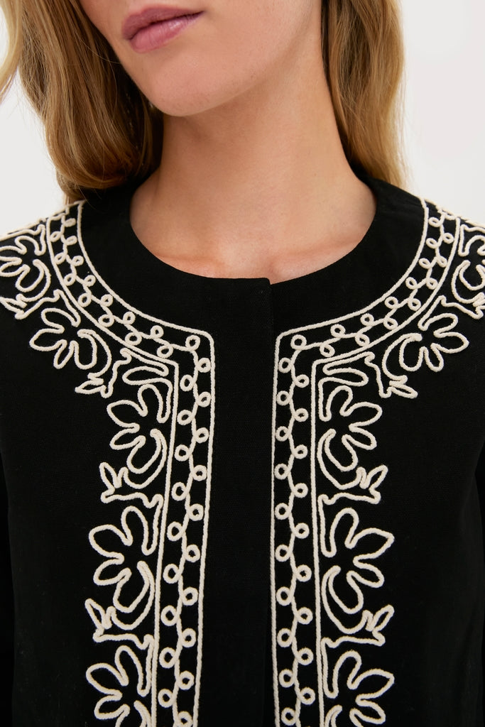 Woman wearing the Soutache Cotton Maddy Jacket, featuring classic embroidered floral and dot motifs, offering an effortless and high-end style.