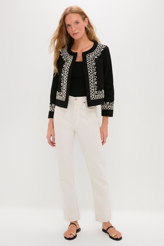 Sleek woman wearing the classic Soutache Cotton Maddy Jacket with white embroidery, paired with high-waisted trousers and chic sandals, embodying effortless, high-end style.