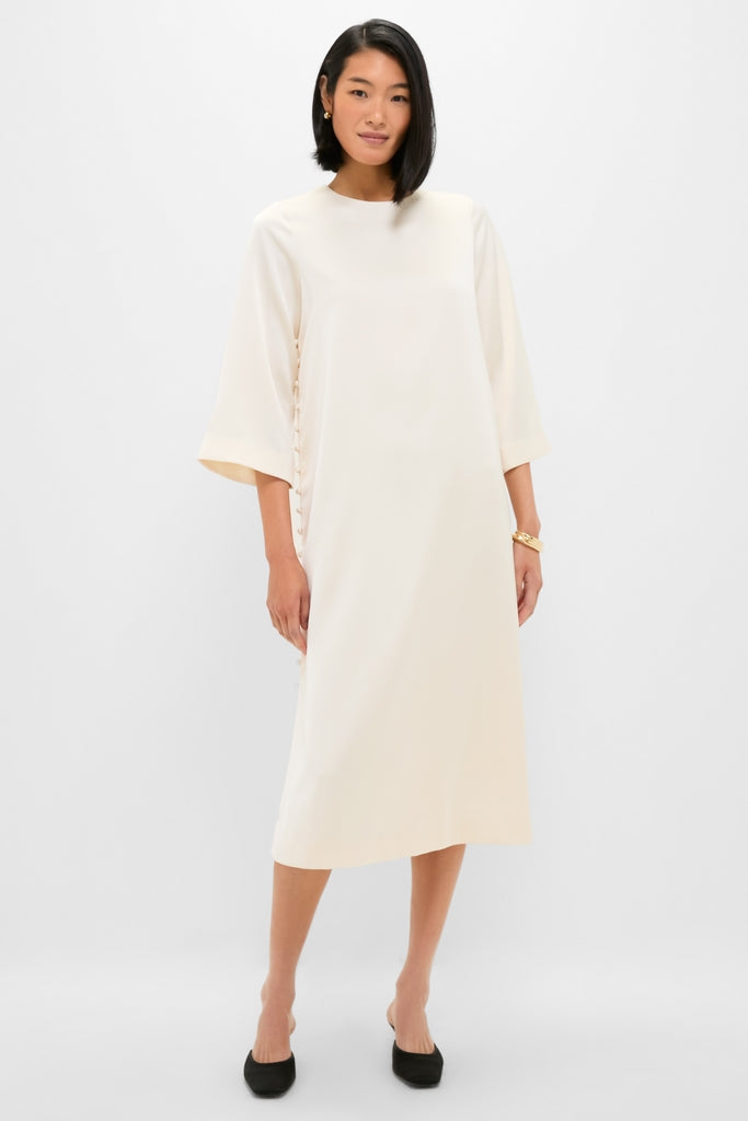 Winter White Side Button Jamie Dress: A classic, effortless midi with elbow-length sleeves and side ties, paired with black pumps and gold jewelry for a fun, high-end look.