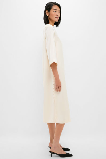 Winter White Side Button Jamie Dress: A classic, effortlessly fun midi dress with elbow-length sleeves and side buttons, paired with black low-heeled mules for a high-end look.