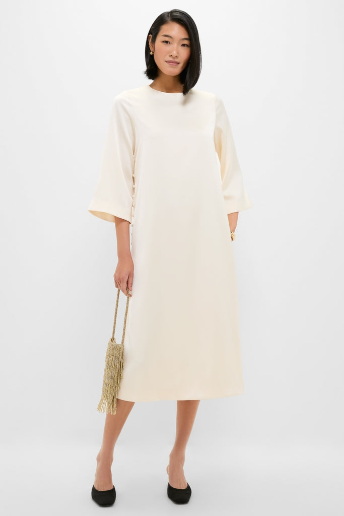 Winter White Side Button Jamie Dress: Classic ivory A-line midi with side buttons, three-quarter sleeves, and high neckline. Effortlessly paired with gold fringe bag and black pumps.