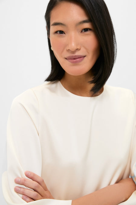 Young woman models the classic Winter White Side Button Jamie Dress, showcasing its relaxed fit and elbow-length sleeves for an effortless, high-end, fun look.