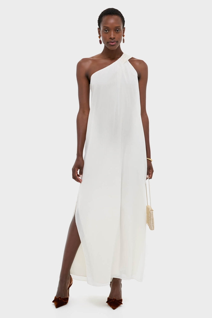 Woman modeling the Ivory Soleil Gown, a classic one-shoulder maxi dress with side slits, styled with elegant accessories for an effortless, high-end look.