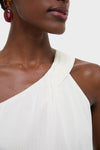 Close-up of a dark-skinned person wearing the Ivory Soleil Gown, showcasing its classic, asymmetrical neckline, embodying an effortless, high-end style perfect for fun wedding events.