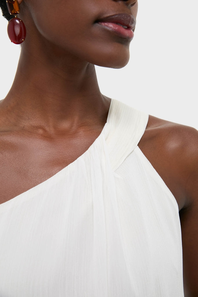 Close-up of a dark-skinned person wearing the Ivory Soleil Gown, showcasing its classic, asymmetrical neckline, embodying an effortless, high-end style perfect for fun wedding events.