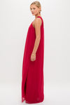 Young woman in profile wearing the Red Soleil Gown, a classic, sleeveless, floor-length dress with a side slit, embodying effortless elegance and high-end style.