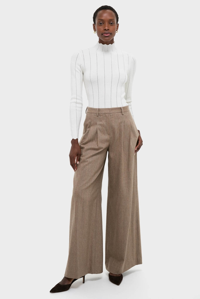 Model wearing the classic White Pointelle Knit Allen Turtleneck with subtle perforated stripes and scalloped mock-neck, paired with effortless, high-end wide-leg pinstripe trousers.