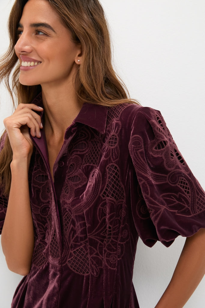Woman in classic Winetasting Velvet Lace Delaney Dress with puff sleeves, showcasing effortless elegance and fun swirling embroidery, embodying a high-end, versatile style.