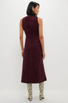 Back view of woman in classic Winetasting Vegan Suede Manon Dress, showcasing effortless, high-end style with panel detailing, paired with fun snakeskin boots and gold hoop earrings.