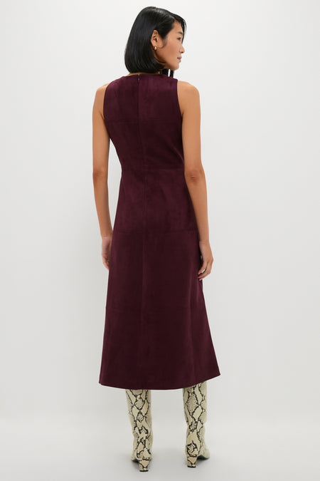 Back view of woman in classic Winetasting Vegan Suede Manon Dress, showcasing effortless, high-end style with panel detailing, paired with fun snakeskin boots and gold hoop earrings.