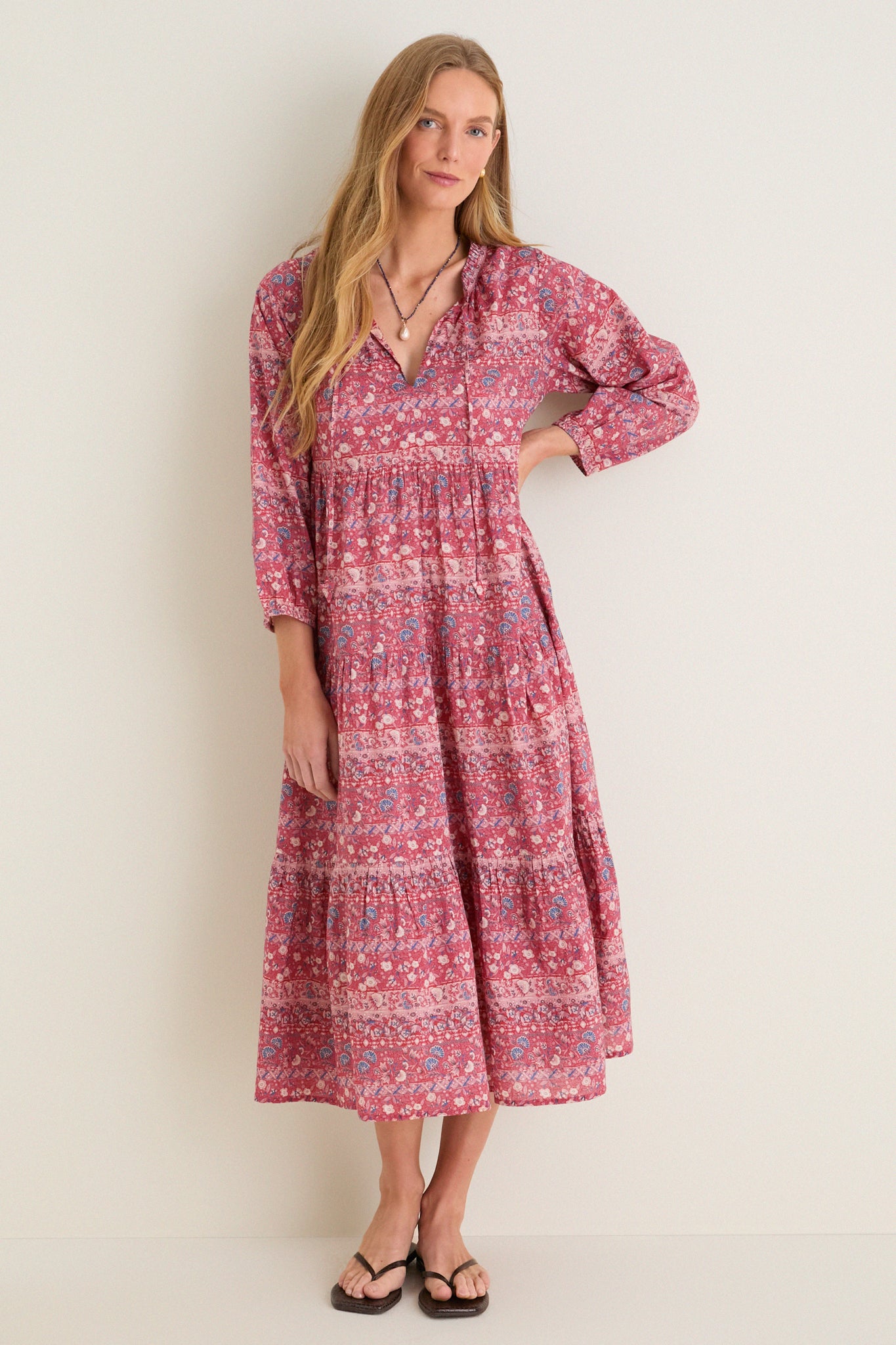 Woman in classic, effortless Americana Batik Stripe Long Sleeve Salty Paloma Caftan, featuring fun tiered skirt, v-neck, and blouson sleeves, epitomizing Tuckernuck's high-end style.